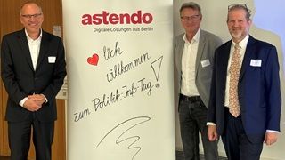 Gruppenbild mit den 3 Speakern zum Politik-Info-Tag neben Roll-up von astendo